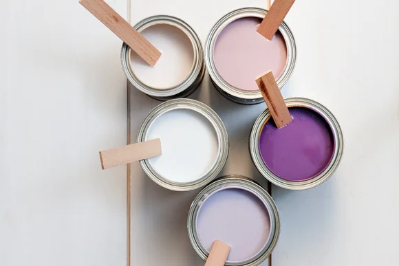 Fünf Farbtöpfe mit Rührstäbchen